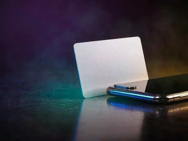 as8 blank card standing beside a smartphone