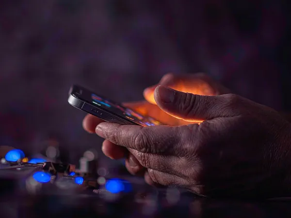 as8 hands holding a smartphone in warm light